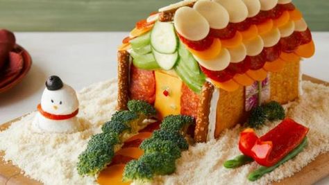 This gingerbread house is overflowing with cheeses, meats and veggies. Cheese And Cracker House, Vegetable Gingerbread House, How To Make A Charcuterie House, Veggie Gingerbread House, Savory Gingerbread House Ideas, Cheese Gingerbread House, Savory Gingerbread House, Charcuterie House For Christmas, Charcuterie Gingerbread House