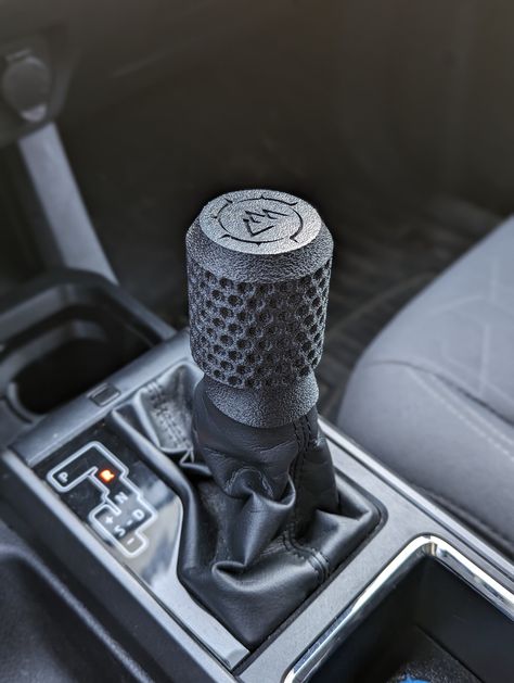 "Mod that Taco out today with a rugged textured aftermarket shift knob. Fits 3rd Generation (2016-2023) Toyota Tacomas Automatic Transmission. These are made out of ASA which is very tough, chemically resistant, and will not degrade in the sunlight. It integrates easily onto your existing Tacoma transmission rod. This one has a textured finish on the bottom and top to hide seam lines and give it an extra rugged look. The threads should be tightened down until the they are fully engaged. Then align the lever with the top of the mountains facing forward and snap the boot onto the clip. CUSTOM LOGO OPTION If a custom logo on top is wanted please choose the \"Custom Logo\" option and send me a message with the details of what you want the logo to be and an image if you have something specific Tacoma Spare Tire Mount, 3rd Gen Tacoma Mods, Tactical Tacoma, Tacoma Grill, Custom Toyota Tacoma, Custom Tacoma, Tacoma 3rd Gen, Taco Board, Toyota Tacoma Accessories