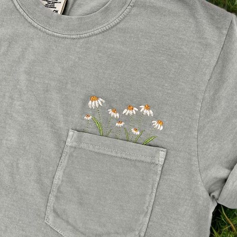 A pocket full of daisies! These embroidered floral pocket tees make the perfect Spring/Summer shirts! Check out our page for these shirts in more designs! **shirt colors may vary slightly from shirt to shirt depending on dye. please use the color chart in the last picture for a truer color** ORDERING & SHIPPING *Your item will be shipped within 5-7 business days. *Please allow 2-5 business days to receive your item, more time may be necessary depending on holidays. *We do not accept returns/refu Embroidered Wildflowers, Embroider Ideas, Embroidered Denim Shirt, Pocket Tees, Embroidered Pocket, Embroidery Tshirt, Floral Embroidery Patterns, Floral Pocket, Embroidery Floral