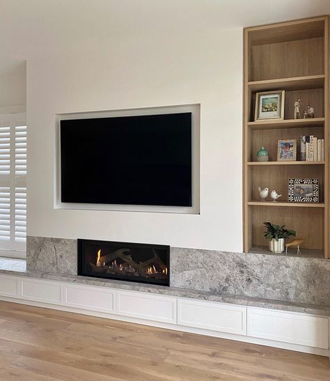 @supresley_id crafted a stunning feature in the living room joinery, incorporating the elegant New Grey Tundra limestone perfectly aligned with the Lopi 4415HO GS2 gas fireplace. The warm timber tones of the display shelving and classic white shaker-style drawers add detail and coziness to this family’s living space.

Interior Design: @supresley_id
Architecture: @hatchprojects
Build: @pkdbuilding
Joinery: @edge_cabinets Low Fireplace Tv Wall, Inbuilt Fireplace, Living Room Joinery, Fireplace With Storage, Living Space Interior, Wood Heaters, Wood Fireplaces, Fireplace Gallery, Space Interior Design