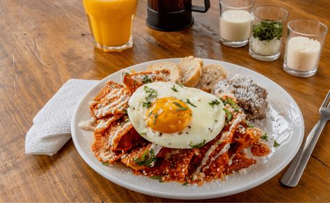 Los chilaquiles rojos con huevo son un desayuno mexicano tradicional, encuentra aqui la receta original para hacerlos desde cero y disfruta Frijoles Refritos, Chile Guajillo, Queso Manchego, Cilantro