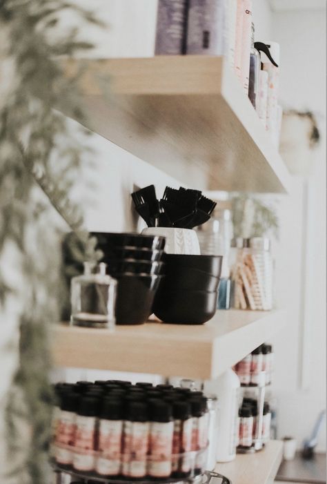 Colorful hair products organized on hanging shelves with plants Salon Suite Shelving Ideas, Hairdresser Organization Ideas, Color Bar Organization, Small Hair Salon Storage Ideas, Salon Color Bar Organization, Salon Bleach Container, Salon Hot Tool Storage, Salon Suite Must Haves, Hair Stylist Organization