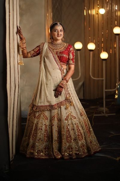 '24 | Bride in TASTA-designed silk beige lehenga red choli adorned with tissue dupatta. The lehenga comprises many large paisley motifs scattered all over adored with a border on the dupatta. Luxury Beige Choli With Dupatta, Golden Chaniya Choli, Festive Gold Tissue Silk Choli, Elegant Red Tissue Silk Choli, Wedding Embellished Tissue Silk Choli, Beige And Red Lehenga, Chaniya Choli Wedding, Chaniya Choli, Bride Clothes