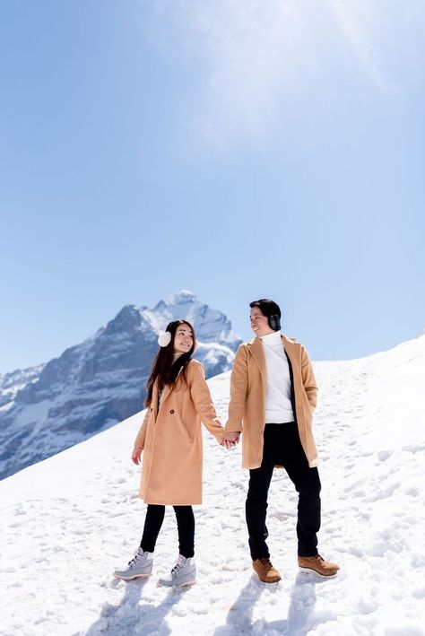 A beautiful spring engagement photoshoot in Grindelwald, Switzerland Switzerland Photoshoot Couple, Switzerland Dress Ideas, Switzerland Photography Couple, Couple Poses In Switzerland, Mt Titlis Switzerland Outfit, Swiss Photoshoot, Snowfall Photoshoot, Switzerland Outfit Ideas, Kashmir Photoshoot