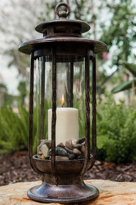 H Potter Small Hurricane Candle Lantern has a cast iron frame with charcoal brown powder-coated finish.   Glass is hand blown and will include occasional bubbles.  Candle not included.  Candle shown in picture is 3 inches wide and 6 inches tall.   Lantern is approximately 19 inches tall 8 inches wide.   This lantern arrives in three pieces:  base unit, glass and lid.  Glass and iron are heavy and durable to withstand the elements.  Decorative hook atop this candle holder is not meant for hanging Large Lantern Decor, Bubbles Candle, Hanging Candle Lanterns, Outdoor Candle Holders, Deck Backyard, Lantern Ideas, Large Lanterns, Lantern Candle Decor, Garden Lanterns