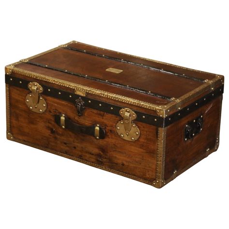 Rectangular in shape and finished on all four sides, this beautiful travel trunk would make an elegant coffee table. Crafted in Paris, France circa 1890 by Pierre de Man in the style of Louis Vuitton, the fruitwood trunk with iron side handles, features decorative brass mounts in the corners, metal straps and wood bands around the front, top and sides; it is further decorated with patinated iron straps around the edges. The chest is dressed with brass nail heads, a front leather handle, and a decorative triple lock mechanism on the facade. The inside is upholstered with white muslin fabric, and the facade is further embellished with a plaque of provenance which reads: "Fabrique d'Articles de Voyage, Maroquinerie, Pierre de Man, 44 rue du Marche, Lille"". The versatile blanket chest is in e Trunks Luggage, Trunk Luggage, Iron Straps, Wicker Trunk, Trunk Boxes, Elegant Coffee Table, Leather Trunk, Antique Trunk, Travel Trunk