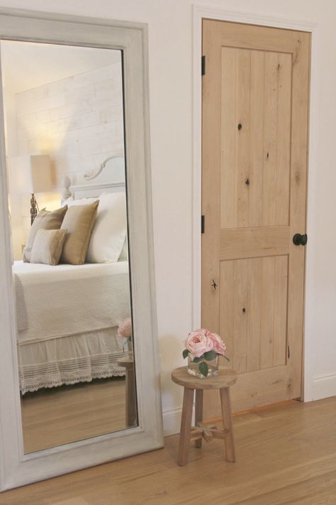 White French country cottage bedroom with Stikwood (hamptons) statement wall, white oak hardwood, and rustic alder doors. #hellolovelystudio #frenchcountry #bedroomdecor #rusticelegance #whiteoak #frenchbedrooms #alderdoor #stikwood #hamptons #romanticdecor #whitebedrooms #interiordesign Bedroom Paint Colors Benjamin Moore, Alder Doors, Knotty Alder Doors, Bedroom Paint Colors Master, White Oak Hardwood Floors, Stained Doors, French Farmhouse Decor, Best White Paint, French Country Bedrooms