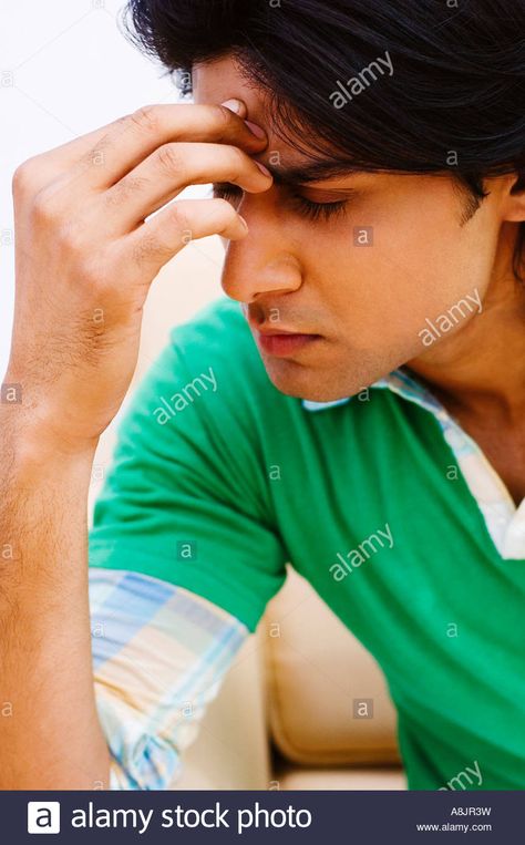 Download this stock image: Close-up of a young man with his hand on his forehead - A8JR3W from Alamy's library of millions of high resolution stock photos, illustrations and vectors. Man With Arms Behind Head, Breaking Out On Forehead, Man Resting Head On Hand, Hand On Forehead, Guy Pointing At Head Meme, Man Face, Live News, His Hands, Male Face