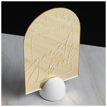 Dimensions: 9.25" H x 5.81" W x 2.88" D Material: Plastic & Resin Shape: Arch Color: Gold & White Orientation: Vertical Quantity: 1 Your wedding is a day to celebrate your love with the people you care about most! Guest Book Mirror Sign is a gold-colored, arched mirror that has the phrase "Please Sign Our Guest Book" on it in white script. It has a white, semi-sphere base with a black, velvety bottom to keep it from falling over. Put out this mirror sign to ensure your guest book is filled with Please Sign Our Guest Book, Mirror Wedding Signs, Wedding Mirror, Mirror Sign, Arched Mirror, Favors Sign, Plastic Resin, Book Ideas, Gold Mirror