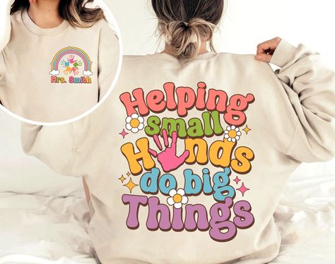 "Teacher Shirt, Helping Small Hands Do Big Things Shirt, Preschool Teacher, Kindergarten Teacher, Back To School, Teacher Appreciation Gift ↓ Click here to view our additional fashionable collections ↓ https://handcraftedbyhelenn.etsy.com Product Details: - 100% Cotton (fiber content may vary for different colors) - Medium fabric (5.3 oz/yd2 (180 g/m2)) - Classic fit - Tear away label - Runs true to size Care instructions: - Machine wash: warm (max 40C or 105F); - Non-chlorine: bleach as needed; Preschool Staff Shirts, Preschool T Shirts For Teachers, Cute Preschool Teacher Shirts, Preschool Tshirt Ideas Teacher Shirts, Preschool Teacher Tshirts, Daycare Teacher Shirts Designs, Kindergarten Shirts For Teachers, Prek Teacher Shirts Designs, Daycare Shirts Teachers