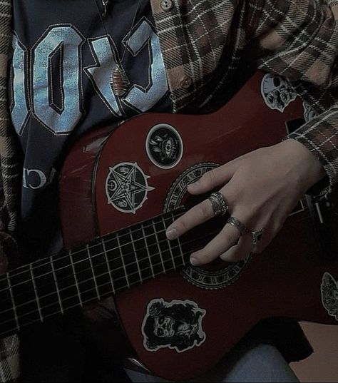 a hand on a guitar Flannel Dark Academia, Wooden Guitar Aesthetic, Dark Musical Aesthetic, Acoustic Guitar Grunge, Dark Academia Instrument, Flannel Grunge Aesthetic, Chill Rock Aesthetic, Aesthetic Guitar Pictures, Guitar Chords Aesthetic