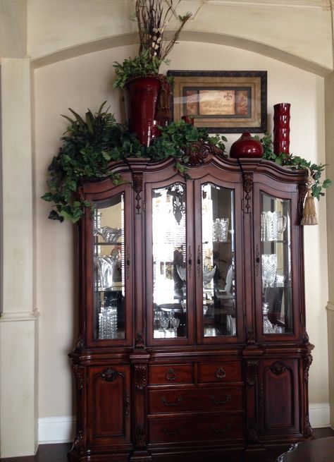 China cabinet decoration -- I would use different colors, but I like the varied heights.  Add lights to the greens? On Top Of Cabinet Decor, Top Of Cabinet Decor, China Cabinet Decor, Above Cabinet Decor, Tuscany Decor, Decorating Above Kitchen Cabinets, Top Of Cabinets, Cabinet Decoration, China Cabinet Display