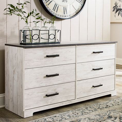 Add homespun charm to your home with the Shawburn Dresser. The two-tone finish keeps this piece light and fresh. The planked dresser top features a rustic gray replicated oak grain finish, while the rest of the piece has a distressed whitewashed worn-through finish. Six smooth-gliding drawers have vinyl-wrapped sides and back for extra durability. Pewter-toned hardware. Meets the most current standard for stability. Drawers extend out for maximum access while maintaining safety. This item cannot Grey Dresser, Full Platform Bed, Six Drawer Dresser, Dresser Top, Queen Panel Beds, Queen Platform Bed, Ashley Furniture Homestore, Panel Headboard, 6 Drawer Dresser