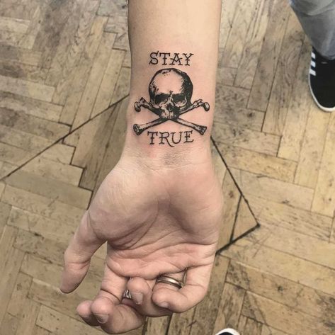 Skull and crossbones with the words ‘stay true’ tattooed on the right wrist by tattooist Annelie Fransson Pirate Themed Tattoos, Stay True Tattoo, Skyrim Tattoo, Pirate Skull Tattoos, Skulls Tattoo, Skull Hand Tattoo, Pirate Tattoo, Petit Tattoo, Wrist Tattoos For Guys