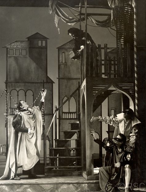 The Merchant of Venice, 1956, the Shakespeare Memorial Theatre. Directed by Margaret Webster, designed by Alan Tagg. Jessica (Jeannette Sterke) hands over Shylock's money to Lorenzo (David William) whilst Gratiano (Andrew Faulds, left) and Salerio (Emrys James, right) stand by. (Photo: Angus McBean). RSC. Angus Mcbean, Merchant Of Venice, Venice Photos, Theatre Scene, The Merchant Of Venice, Shakespeare Plays, Scene Design, Performing Arts, The Money