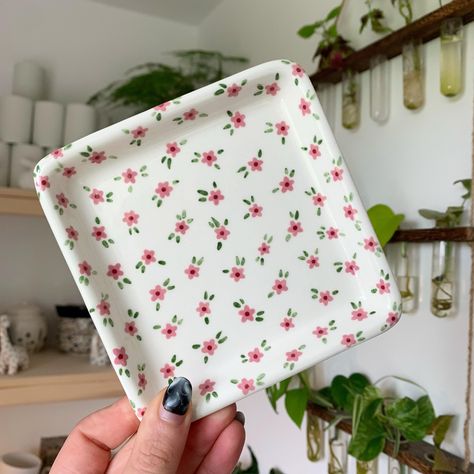 Square trinket tray with little pink flowers 🌸✨🌱 Lots of things available on my website now - link in bio ✨🥰 #art #artist #ceramics #pottery #painting #illustrator #ceramicstudio #potterytiktok #potterypainting #painter #trinkettray #smallbusiness Jewelry Tray Painting Ideas, Trinket Tray Painting Ideas, Pottery Painting Jewelry Dish, Pottery Trinket Dish, Tray Painting Ideas, Painted Trays Ideas, Tray Painting, Clay Cafe, Korean Pottery