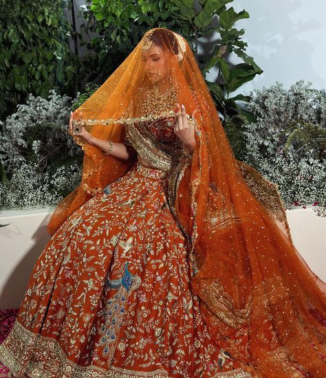 Get ready to be amazed by this stunning burnt orange bridal joda! Inspired by the beauty of lotus flowers and the magnificent peacock, this outfit is a masterpiece of intricate detailing and vibrant colours. The flying peacock motifs not only bring an element of positivity but also exude elegance. Complete with a graceful veil and a border dupatta, this ensemble is a true embodiment of grace and beauty. Style by @devampandeyofficial Jewellery @rang.mahal.jewels White Lehenga With Green Dupatta, Orange Wedding Lehenga Indian Bridal, Orange Lehenga Bridal, Orange Wedding Lehenga, Burnt Orange Lehenga, Orange Bridal Lehenga, Flying Peacock, Dupatta Setting, Rang Mahal