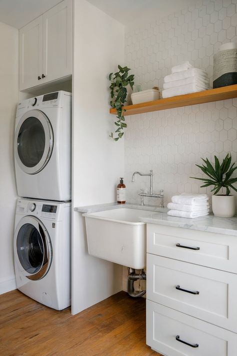 Laundry room with a functional slop sink, open shelving, and a stacked washer and dryer for practical use. Small Laundry Closet With Sink, Laundry Room Slop Sink Ideas, Half Bath With Washer And Dryer, Slop Sink Ideas, Small Laundry With Sink, Small Laundry Room With Sink, Slop Sink, Hexagon Tile Backsplash, Small Laundry Room Ideas