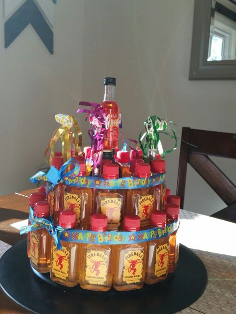 Fireball cake!  made from a charger plate, round foam cake form, and fireball shooters. I added 2 jagers in the middle and a cherry one on top to get a total of 36 shots. (was for a 36th birthday party) hot glue them to the foam and I added ribbon just to be safe Fireball Bucket Ideas, Shooter Cake 21st, Fireball Birthday Cake, Fireball Shooters, Mini Bottle Cake, Fireball Gift Ideas, Fireball Cake, Mini Alcohol Gifts, Liquor Bottle Cake