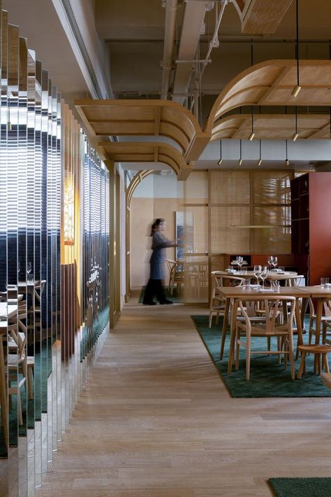 The 336 sqm restaurant intersects European and Asian cuisine in an eclectic space inspired by Scandinavian folk art, Peranakan architecture, and art, paying homage to the Singaporean cultural scene. The space is characterized by an interplay of hues ranging from warm, earthy tones to deep, tropical greens, with brass details. The color palette is reminiscent of the rustic Scandinavian cabins and the abundant green of tropical Singapore #architonic #interiors #interiorlovers #interiordesire Scandinavian Restaurant Interior Design, Rattan Ceiling Design, Tropical Cabin, Peranakan Design, Restaurant Partition, Asian Restaurant Design, Nordic Background, Scandinavian Cabins, Scandinavian Ceiling