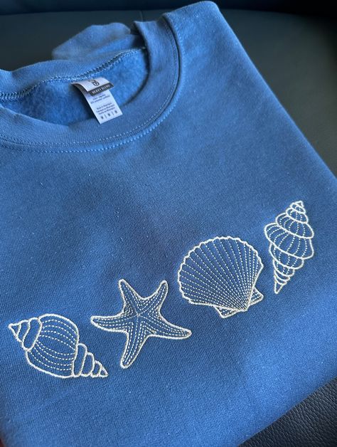 Perfect for a seaside trip, or throwing it on after a beach day! Cute embroidered seashell sweatshirt a great addition to your closet.  Custom Available:  - Size can be made bigger if required, please reach out to us - different color sweatshirts available, Crewnecks & Hoodies - different thread colors available  If you would like to purchase multiple sweatshirts or a different color or a change in design, please contact me first!  All requests are welcome! Sizing : These sweatshirts are in ADUL Embroidery Designs For Tshirts, Graphic Designs For Shirts, How To Embroider By Hand On Clothes, Embroidery Designs Shirt, Embroidery Designs Tshirt, Simple Sweatshirt Design, Embroidery Designs Sweatshirt, Embroidery Sweatshirt Ideas, Hand Embroidery Sweatshirt