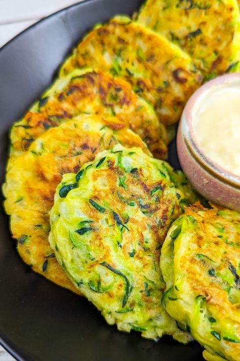 Enjoy simple and flavorful 4-Ingredient Zucchini Fritters! Made with shredded zucchini, flour, egg, and onion. Versatile and delightful as a snack or appetizer. Get creative with herbs and spices! Zucchini Biscuits, Using Frozen Zucchini, Zuchinis Fritters Recipe, Zucchini Fritters No Flour, Best Zucchini Fritters Recipe, Shredded Zucchini Recipes, Zucchini Cottage Cheese Fritters, Zucchini Fritters No Egg, Zucchini Patties