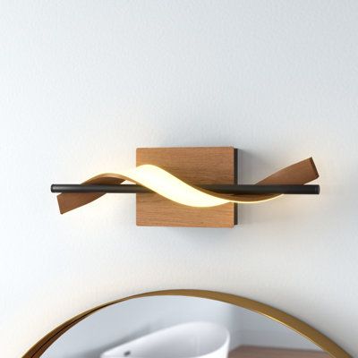 Bring a unique touch to your bathroom with this 1-light geometric vanity fixture. Crafted from aluminum and iron, it features a rectangular backplate and a wood-grain finish that's easy to coordinate with your bathroom's style. A single ribbon-like bar twists and curls around a pipe-inspired arm, forming a swirling helix silhouette and a modern look. A 12W integrated LED strip provides bright, bold illumination. We love that you can mount this vanity light either up or down, depending on your pr Bathroom Vanity Lighting Unique, Unique Vanity Lighting, Vanity Lights, Bedroom Vanity, Led Vanity, Drum Chandelier, Bathroom Wall Lights, Bath Bar, Bathroom Light Fixtures