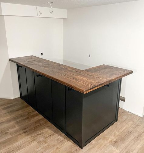 L-shaped bar for this newly renovated basement! 🖤 finished in a tricorn black base and Dark Walnut stain on a wooden oak top. 

Keywords: L Shaped Bar, Bar Unit, Basement Bar, Basement Ideas, Basement Inspiration, Basement Inspiration, Downstairs Bar Unit, Downstairs Bar, Custom Bar Unit, Custom Bar, Custom Furniture, Custom Woodworking, Wood Bar. Basement Bar Remodel Before And After, L Shaped Bars Basement, Cheap Basement Bar Ideas, Basement Bar Top Ideas, L Shaped Dry Bar, Basement Bar Area Ideas, Small Bar Basement Ideas, Basement Kitchen With Bar, Diy Bar In Basement