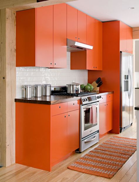 A bold orange cabinet color provides a brilliant contrast to this room's crisp black countertops and shiny white backsplash. #orangecabinets #kitchencabinets #kitchencolors #boldkitchen #bhg Orange And White Kitchen, Orange Kitchen Cabinets, Orange Cabinets, Orange Kitchen Decor, Best Kitchen Colors, Deco Orange, Kitchen Cabinets And Countertops, Painted Kitchen Cabinets Colors, Kabinet Dapur