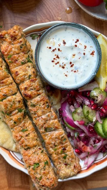 Iram Mansoor on Instagram: "Sheet Pan Chicken Kebab with Onion, Tomato, Cucumber Pomegranate Salad and Garlic Yogurt Sauce

Minced Chicken Kebab:

Ingredients:

- 2 lbs boneless, skinless chicken thighs, minced
- 1 large red onion, finely chopped and squeezed
- 1-2 jalapeños, finely chopped
- 8-9 cloves fresh garlic, minced
- 1 tbsp freshly minced parsley
- 2 tbsp tomato paste
- Salt, to taste
- 1 tsp black pepper
- 1 tbsp garlic powder
- 1 tbsp onion powder
- 1 tsp ground cumin
- 1 tsp red chili flakes
- 3 tbsp oil

For the Onion, Tomato, Pomegranate Salad:

Ingredients:

- 1 cucumber, sliced
- 1 red onion, sliced
- 1 large tomato, seeded and finely chopped
- 1/2 cup pomegranate seeds
- 1 tbsp freshly chopped parsley
- Salt, to taste
- 1 tsp sumac
- 1 tsp lemon juice
- 2 tbsp olive oil

F Garlic Yogurt Sauce, Garlic Yogurt, Minced Chicken, Chicken Kebab, Pomegranate Salad, Sheet Pan Chicken, Chicken Recipies, Tomato Cucumber, Middle Eastern Dishes