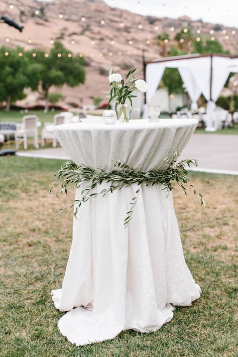 Olive Leaf Cocktail Table Sashes. Unique cocktail table ideas. Sparkle Linens with Greenery Tie Backs - By: LadyLibertyEvents.com #moderngardenwedding Wedding Cocktail Table, Wedding Ceremony Unity Candle, Bohemian Wedding Ceremony, Wedding Cocktail Tables, Ceremony Decorations Outdoor, Wedding Ceremony Decorations Outdoor, Bridal Party Tables, Wedding Ceremony Unity, Boho Wedding Ceremony