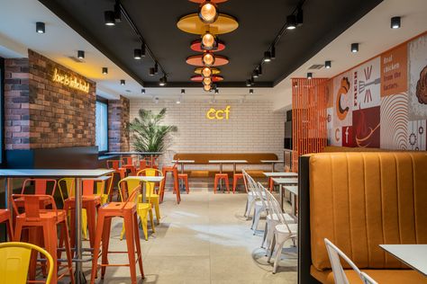 Upstairs guest area with colorful metal chairs, tile with colored edges, led brand logo, and interior plant. Crispy Chicken Factory by miaza design studio in vienna finished in 2023 Design Studio Interior, Furniture Concept, Small Restaurant Design, Fast Chicken Recipes, Open Restaurant, Cafe Wall Art, Small Restaurant, Cafe Wall, Interior Plants