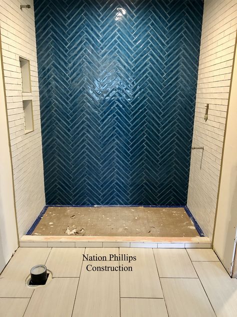 Beautiful peacock blue tile feature wall installed in a herringbone pattern. #anthologytile #watercolors #rustictile #blueherringbone Teal Herringbone Tile Bathroom, Blue Tile Accent Wall Bathroom, Blue Herringbone Shower Tile, Navy Blue Herringbone Tile Bathroom, Dark Blue Herringbone Tile Bathroom, Bathroom Blue Tile Wall, Navy Herringbone Tile Bathroom, Herringbone Accent Wall Bathroom, Tile Feature Wall Bathroom