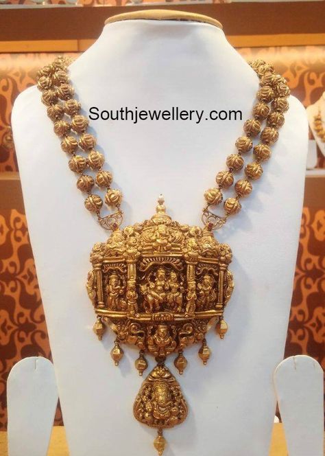 22 carat gold antique finish two line nakshi balls necklace featuring beautiful Nakshi work temple pendant embossed with Lord Shankar and Ganesh. For inquiries contact: Naj Jewellery, Nellore Email : mynaj@najindia.com Temple Jewelery, Rudraksha Jewelry, Latest Indian Jewellery, 22 Carat Gold Jewellery, Temple Jewelry Necklace, Gold Temple Jewellery, Antique Jewellery Designs, Gold Necklace Indian Bridal Jewelry, Antique Bridal Jewelry