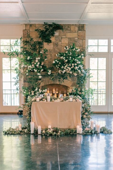 Sweetheart Table In Front Of Fireplace, Fireplace Sweetheart Table, Sweetheart Table Fireplace, Sweetheart Table Wedding Backdrop Floral Design, Floral Arch Sweetheart Table, Sweetheart Table Candles, White Florals Sweetheart Table, Wild Flower Sweetheart Table, Ground Florals Sweetheart Table