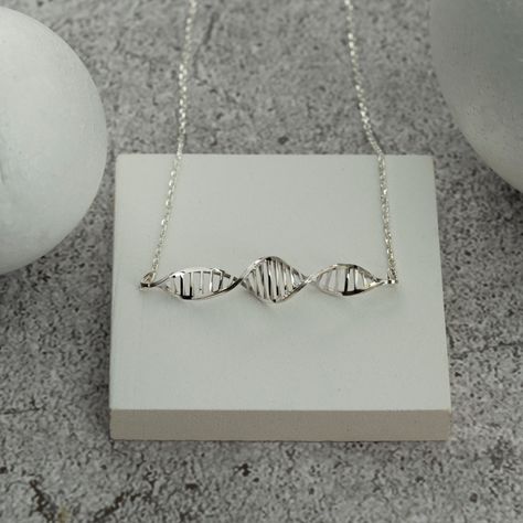 The DNA necklace is a stunning piece that elevates the passion of science enthusiasts. Its elegance and design are crafted to make you feel wonderful. The Molecule Pendant is an ideal gift for healthcare professionals. A thoughtful gift for aspiring medical students. A delightful gift for Valentine's Day. Explore DNA Earrings options. Expertly crafted from 925 sterling silver just for you. TECHNICAL INFORMATION - Chain length: 16+2 (40+5cm)- Pendant height: 0.28 Inches (7mm)- Pendant width: 1.5 Dna Necklace, Dna Earrings, Molecule Necklace, Personalized Wedding Rings, Science Jewelry, Engraved Wedding Rings, Engraved Engagement Ring, Doctor Gift, Mother Day Gift