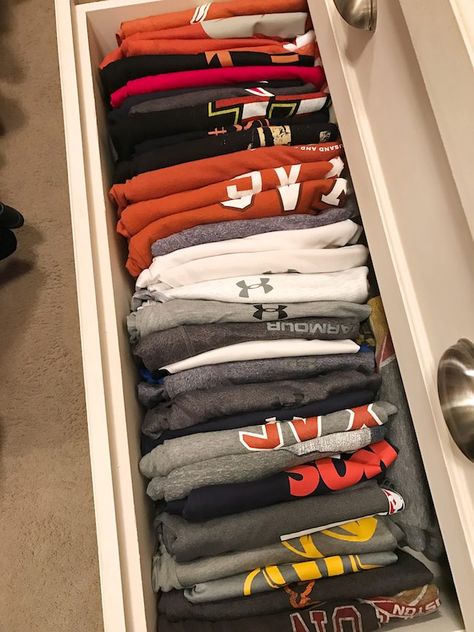 While the majority of our household organization is my territory, even my husband gets the urge to clean out and organize in the new year!  He’s been on a roll with his home office and closet #gobabe!, and I thought it might be useful to you if I showed you how I organized his t-shirt drawer.   You guys know I’m crazy for the Kon Mari Organizing book, our home got a pretty good overhaul after I read it.  You can see how I cleaned up our books and linen closet for example, T Shirt Drawer Organization, T Shirt Closet Organization, Organizing Sweatshirts In Closet, Ways To Organize Shirts In Drawers, Organize Tshirts In Drawer, Drawer Organization Clothe, Men’s Organized Closet, Clothes Dresser, Clothing Drawers