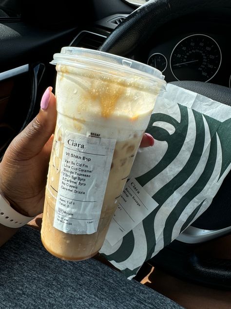 A Venti Iced Shaken Espresso from Starbucks with customized syrups and caramel drizzle, held in a hand with a pink manicure, with a Starbucks sandwich bag in the background. Starbucks Shaken Espresso, Starbucks Coffee Orders, Iced Shaken Espresso, Blonde Espresso, Vanilla Sweet Cream, Shaken Espresso, Starbucks Order, Best Iced Coffee, Caramel Drizzle