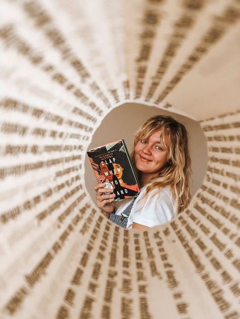 A blonde white woman with wavy hair is holding the book "Clap When You Land" by Elizabeth Acevedo. The camera is framed by a book page, rolled, so it centers the woman in the frame. Creative Book Pictures, Book Lovers Profile Pics, Book Selfies Ideas, Book And Food Photography, Book Release Photoshoot Ideas, Photo With Books Ideas Instagram, Bookstagram Birthday Post, Creative Bookstagram Photos, Book Instagram Photo Ideas