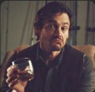 A picture of Will Graham (Hugh Dancy) with a glass of whisky, shrugging, with his mouth downturned and raised eyebrows. Glass Of Whisky, Will Graham, Hugh Dancy, Eyebrows, Glass