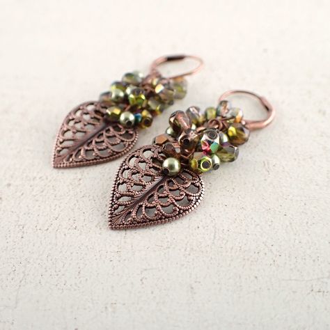 Clusters of light green crystal pearls and iridescent green Czech glass beads atop beautifully detailed heart-shaped leaf filigree drops. The Czech beads are mostly green, but have the occasional flash of fuchsia. The earrings feature antiqued genuine copper lever back ear wires for added security. --------------------------------------------------------------------------------------------- Dimensions and details: - From the top of the ear wires to the bottom of the earrings, they measure approx Leaf Filigree, Jewelry Fabric, Witch Shop, Copper Leaf, Witchy Crafts, Beaded Beads, Diy Jewelry Inspiration, Bead Projects, Filigree Jewelry