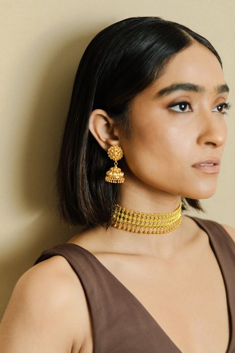 Introducing the timeless elegance of our 22k gold oxidized choker set, perfect for the traditional Indian bride. This stunning set features intricate designs and is handcrafted to perfection, making it a true masterpiece of Indian bridal jewelry. The oxidized finish adds a touch of rustic charm to the set making it perfect for a bride who wants to stand out. The set includes a choker necklace, matching earrings and maang tikka. Shop now and add a touch of traditional charm to your bridal look.