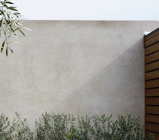 smooth, light grey stucco walls at existing building. Stucco Courtyard Walls, Light Grey Rendered House Exterior, Plastered Garden Wall, Stucco Aesthetic, Exterior Wall Finishes Texture, Stucco Exterior Wall Fence, Stucco Cinder Block Wall, Limewash Render Exterior, Stucco Fence Wall Modern