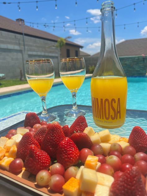 brunch by the pool including two glasses of mimosas with a mimosa glass bottle and a platter of cheese and fruits including strawberries and grapes Mimosa Aesthetic, Artist Retreat, Vacation Food, Miami Vibes, Tropical Food, Picnic Aesthetic, Vacation Meals, Summer Lifestyle, Fruit Summer