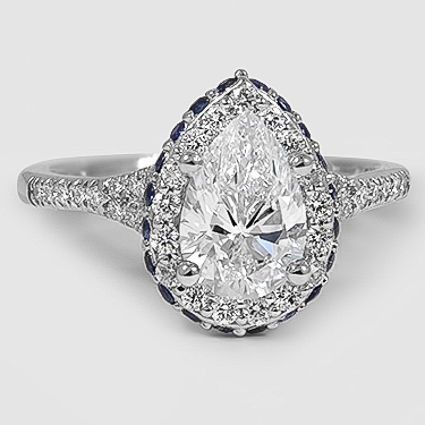 A halo setting is made even more glamorous by vibrant sapphires pavé set around the exterior edge of the halo. Diamond Ring With Sapphire, The Bling Ring, Halo Setting, Bling Rings, Halo Diamond Ring, Diamond Solitaire Rings, Pear Diamond, Dream Ring, Fine Rings