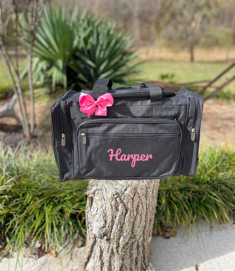 "Are you looking for a personalized lightweight solution for carrying your essentials? These wonderful Black Duffle bags are perfect for dance bags, overnight trips, weekender bags, work trips, work bags, vacation bags, bags for school, luggage, carry-on bag, dance bag, ballet bag, cheer bag, gym bags, team bags, teacher bags, bridesmaid gifts and so much more.  These bags are also great for nurses or healthcare workers.  These make perfect personalized unique gifts for friends, family, or yourself for birthdays or holidays. Lots of room for storage or organization. This is our bestseller black glitter duffle bag. I try to match bows to thread color choice.  If you I do not have that specific color, I use black bows.  These bags would make great team bags, and great gifts.  Soft Canvas Gli Cheer Duffle Bags Personalized, Cheer Duffle Bag, Personalized Duffle Bag, Gymnastics Bags, Black Duffle Bag, Cheer Bag, Ballet Bag, Black Bows, Weekender Bags