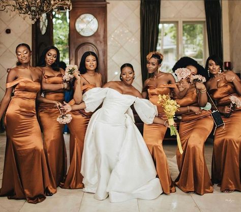 Bridesmaids in Brown Satin Dresses in Nigerian Bridal Train - Latest Styles 2021 as seen on www.weddingfeferity.com. Long off-shoulder satin or silk bridesmaids dresses, with peach floral bouquet with six nigerian bridesmaids. See more wedding inspiration, ideas and planning tools and advice on the website Nigerian Bridesmaid Dresses, Brown Wedding Themes, Latest Bridesmaid Dresses, Brown Bridesmaid Dresses, White Wedding Ceremony, Bridal Squad, Party Colors, White Bridesmaid Dresses, Bridesmaids Photos