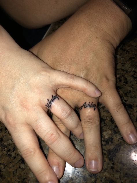 Tattoos Of Names Boyfriends, Tattoo On Ring Finger Name, Hubby Tattoo Ideas, Couples Ring Finger Tattoo Ideas, Wedding Band Tattoo Ideas For Couples, Name Tattoos Finger, Husband Name Tattoo Ideas, Name Ring Tattoo, Wedding Ring Finger Tattoos Initials