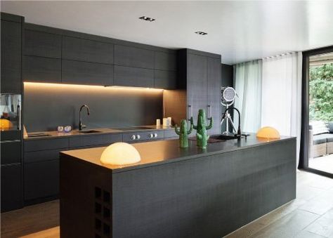 Black cabinets with black countertops is a sophisticated and sleek solution for any modern and daring kitchen. Read on for more kitchen cabinet paint color tips and ideas. Modern Konyhatervezés, One Wall Kitchen, Modern Black Kitchen, Outdoor Kitchen Appliances, Modern Kitchen Cabinet Design, Dark Kitchen, Wall Kitchen, Kitchen Designs Layout, Kitchen Splashback