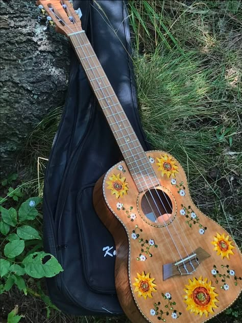 This is a sample of my Sunflower and Daisy Vine design on  a Kmise brand ukulele with tiger flame okoume wood body and classical design tuners. Shown on a baritone size. Your hand-painted design will be very similar, but each is hand-painted with slight variations. After painting the design, the top is coated with a satin polyurethane varnish for protection against wear. This is a great playing uke as well as beautiful to look at, a little more expensive than my standard brands, but well worth i Decorated Guitar Aesthetic, Paint Ukulele, Paint On Guitar, Ukulele Design Painted, Painted Ukulele Aesthetic, Painted Guitar Acoustic, Guitar Design Ideas, Painting On Guitar, Decorated Guitar